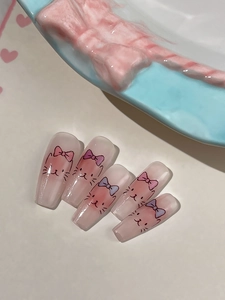 Detail of pink and white gradient nail stickers with cute cat faces and colorful bows
