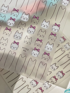 Detailed view of white cartoon cat nail stickers with pink bows and YT7352 ID label