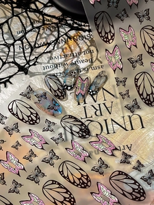 Detail von dunklen Schmetterlings-Nagelstickern und Gothic-Nailart mit Spitzenakzent