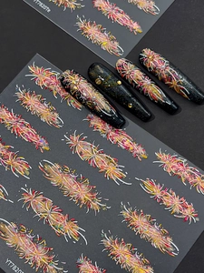 Macro shot of 3D firework nail stickers in red and gold on long black stiletto nails
