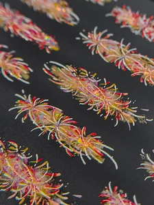 Macro view of holographic firework nail stickers with laser glitter on black background