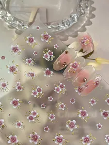 Detail of pink cherry blossom nail stickers with gold edges on gradient manicure
