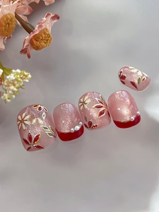 Macro detail of floral nail art with gold edges, cat-eye finish and small pearls