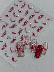 Detail of red butterfly nail stickers with silver glitter on long false nails