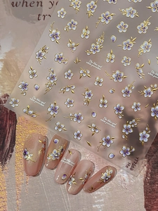 Detail of blue and white porcelain style nail stickers with gold outlines and purple flowers