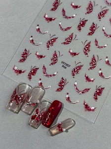Detailed view of red butterfly nail stickers with silver outlines and sample nail art