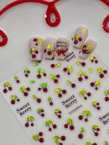 Macro detail of 3D cherry nail stickers YT7576 with metallic red finish on white plate