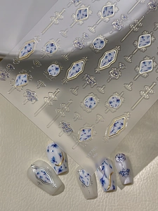 Detail of blue floral nail art stickers with gold geometric patterns and finish results