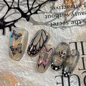 Gothic-Schmetterling-Nagelset mit schwarzen Flügelmustern und Silberstern auf Magazin