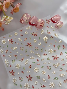 Detailed view of floral nail stickers with gold foil edges and pearl bead accents