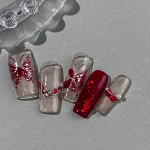 Red butterfly nail art stickers with glitter pearls and rhinestones on five display tips
