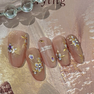 Blue and white porcelain style press-on nails with purple flowers and gold glitter accents