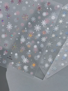 Vue détaillée d'autocollants pour ongles flocon de neige blancs et holographiques