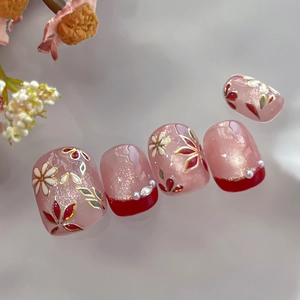 Elegant press-on nails with red French tips and gold floral accents in Japanese style