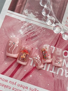 Detailansicht handgefertigter rosa Kunstnägel mit 3D-Schleife und Kristalldetails