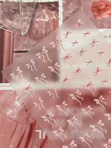 Nahaufnahme von rosa Schleifen-Nagelstickern mit Strasssteinen und süßen 3D-Band-Designs