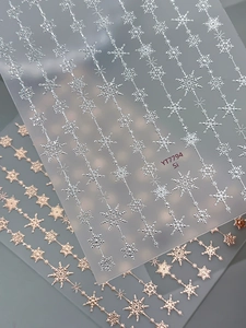 Detail of 5D embossed snowflake nail stickers in silver and rose gold metallic finishes