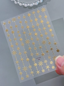 Detailed view of golden snowflake nail art stickers with geometric metallic patterns