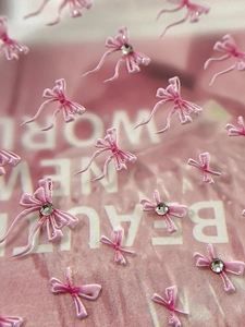 Detailansicht von 3D-Schleifen-Nagelstickern in Rosa mit glitzernden Kristallen
