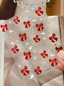 Close-up of YT7909Pro 3D nail stickers featuring red bows and white snowflakes motifs