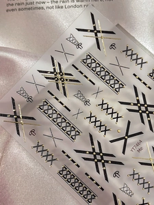 Vue détaillée d'autocollants pour ongles à motifs rubans noir et or avec relief