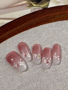Macro detail of floral nail art stickers with pink ombre and dainty white flower patterns
