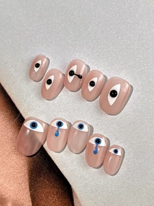 Macro shot of 10-piece nail art stickers with funny eye designs and blue 3D tear drops