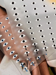 Detail of creative eye-shaped nail art stickers with blue and black pupil designs