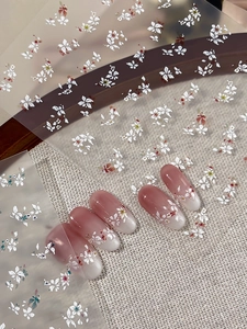 Close-up of floral nail art stickers with delicate pink and white cherry blossoms