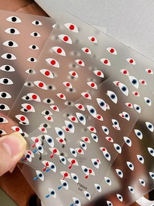 Detailed view of fun eye pattern nail stickers with red and blue pupil designs