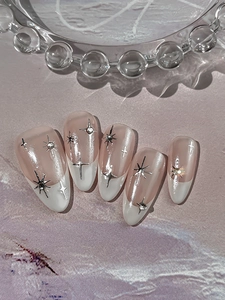 Detailed view of almond-shaped press-on nails with nude pink base and French white tips