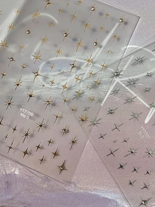 Detail view of gold and silver star nail art stickers with 3D crystal accents