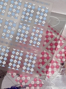Détail macro de stickers pour ongles à motif de losanges et cœurs en bleu et rose