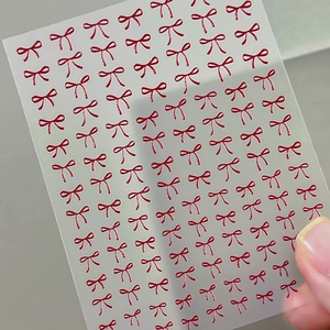 3D embossed red bow nail art stickers set on clear sheet for professional manicures