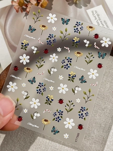 Detail of 3D embossed nail art stickers with daisy and sunflower designs for DIY manicures