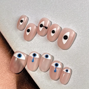 Minimalist press-on nails set with funny eye patterns and blue 3D teardrop details
