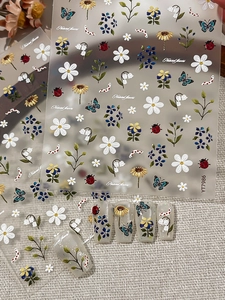Detailed 3D embossed nail stickers with sunflowers and insects on sample nail tips
