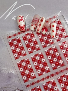 Détail de stickers à ongles de Noël rouges et blancs avec motifs de rennes et de flocons