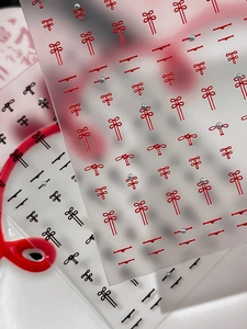 Macro view of bowknot nail stickers with silver beads in red and black designs