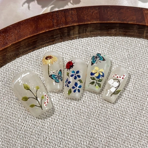 5pcs set of floral press-on nails with sunflower and butterfly designs on milky white base