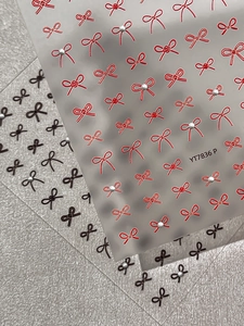 Detail shot of YT7836 bow nail stickers featuring red and black bows with white pearls
