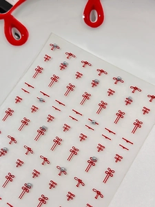 Macro shot of 3D red Chinese knot nail art stickers with silver pearls for Lunar New Year