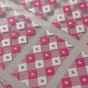 Stickers nail art à damier rose et blanc avec motifs de petits cœurs sur surface mate