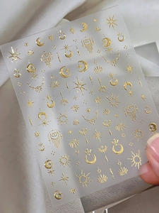 Detail of 3D gold foil nail art sticker featuring celestial stars and moon symbols
