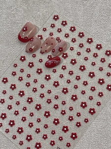 Macro detail of red 3D embossed flower nail art stickers with elegant floral designs