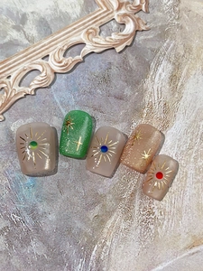 Detailed view of luxury press-on nails with star patterns and gemstone embellishments