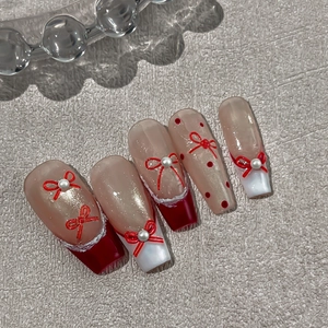Long ballet press-on nails with red bows, pearls, and french tips on pink base
