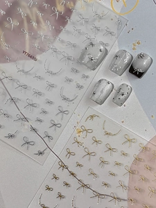 Detailed close-up of 3D metallic ribbon bow nail stickers with gold and silver textures