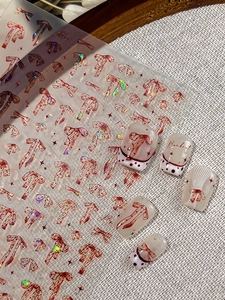 Macro detail of red bowknot nail art stickers with glitter finish and polka dot accents