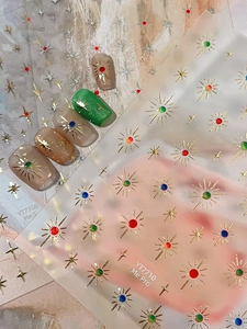 Detailed starburst nail stickers with colorful crystal accents and 3D textured sunburst design